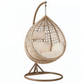 Poltrona sospesa in fibra intrecciata beige con struttura in metallo, stile boho da interno, misura 110x110x195 cm.